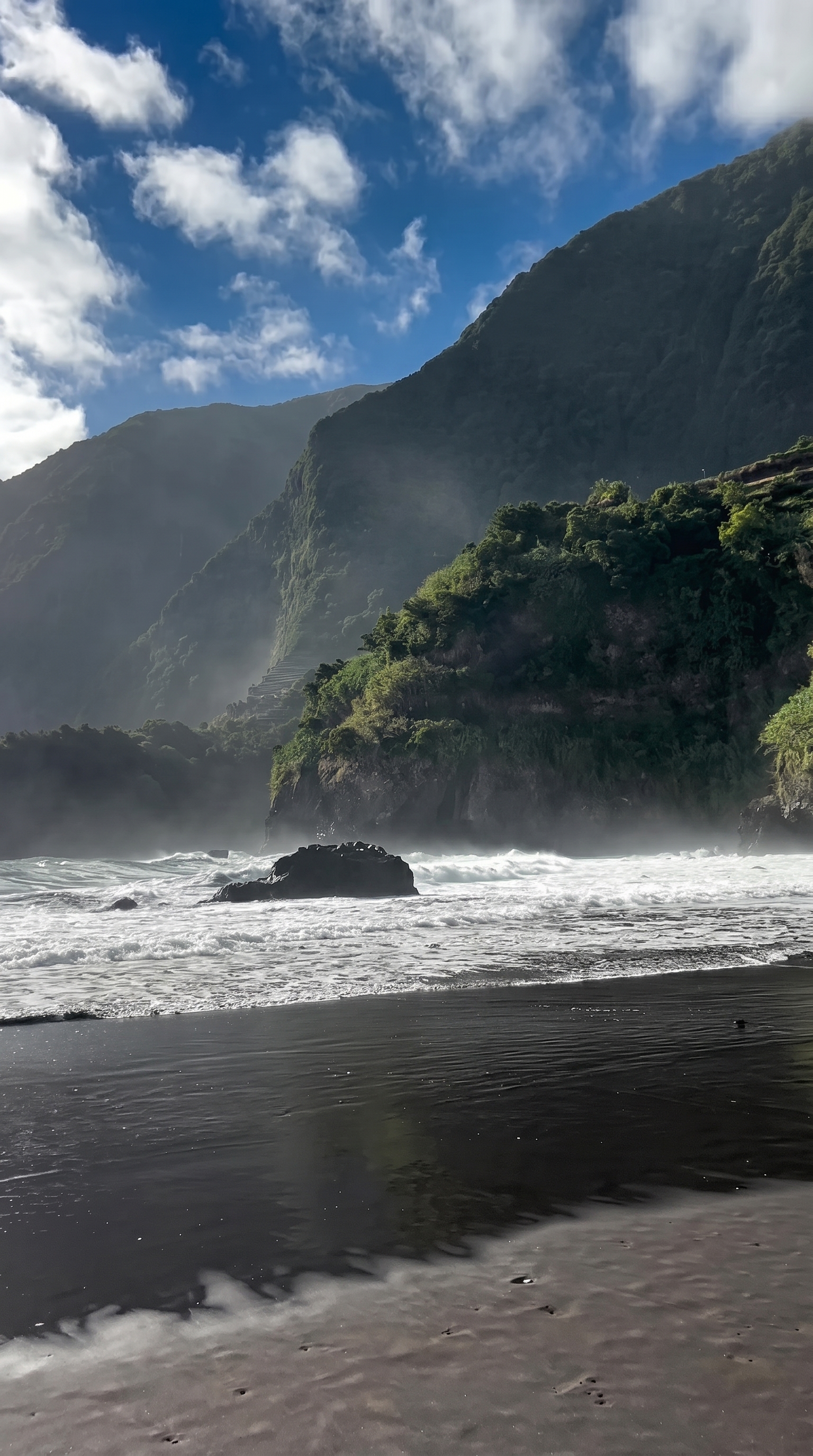 Seixal black sand beach with volcanic cliffs and ocean mist on Madeira's north coast